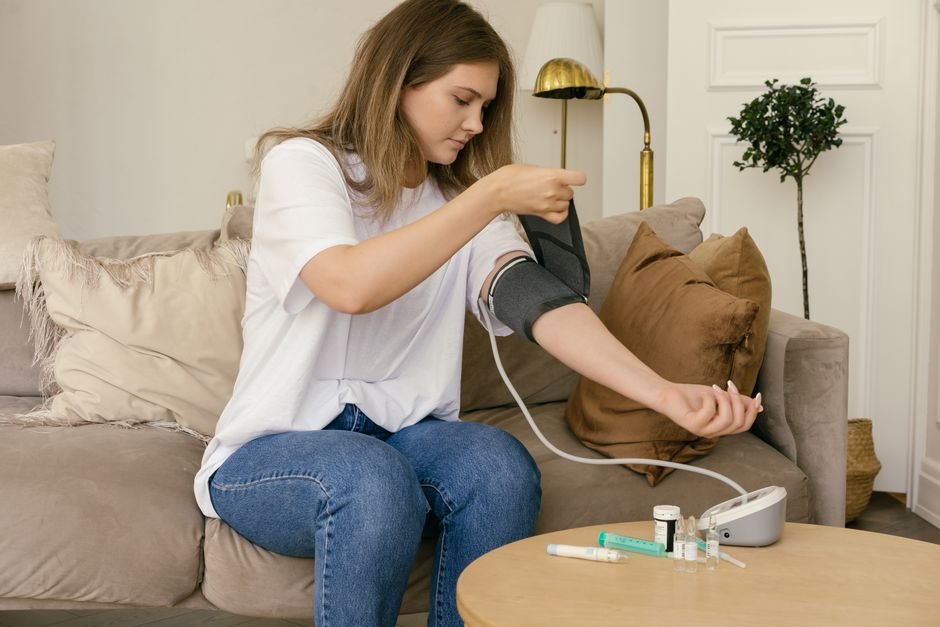 Woman using a digital blood pressure monitor at home as part of a remote patient monitoring program